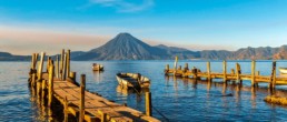 Fotografía del embarcadero de madera del lago Atitlán con el volcán al fondo del paisaje